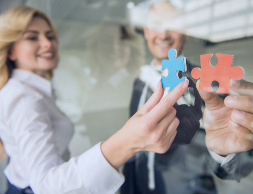 A team meeting to discuss a global payroll transformation solution. Diverse professionals are evaluating options that address global payroll challenges like compliance, processing, and services. The goal is to streamline global payroll for improved efficiency.