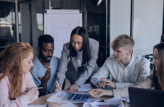 A business meeting focused on deploying Neeyamo's Global Payroll solution. The group is discussing how to streamline payroll processes for their international operations using a single, unified platform.