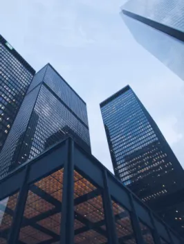 Skyscrapers reaching towards a dusky sky, their geometric facades a testament to technology-enabled architecture's grandeur.